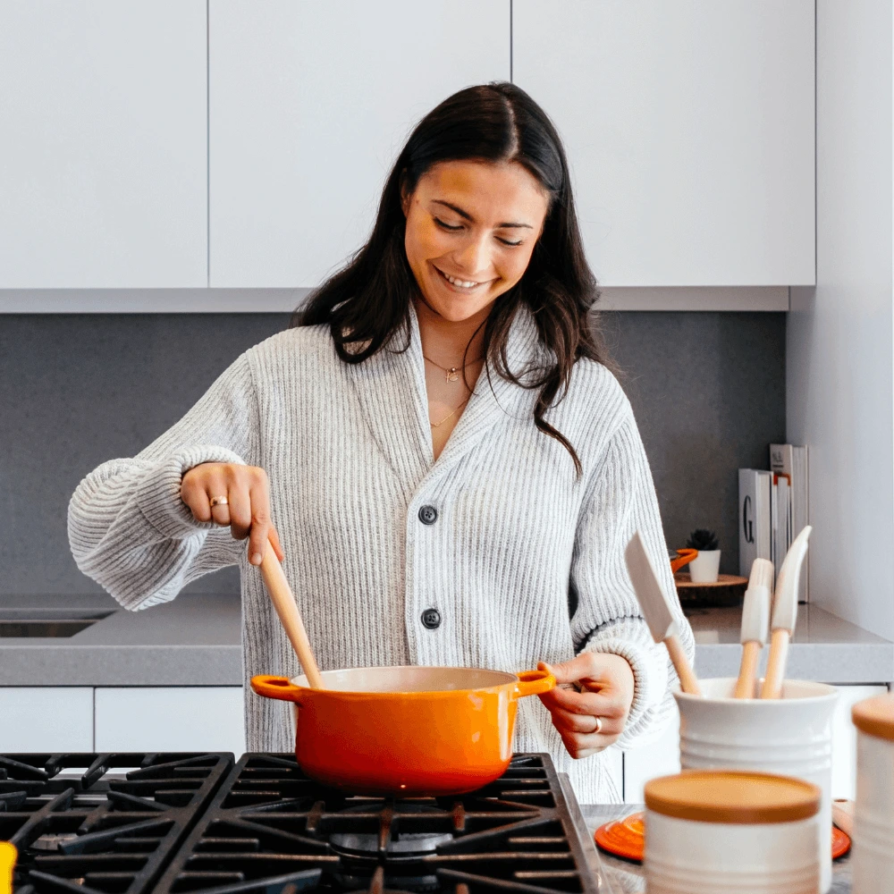 About me 1 Ellie Monroe in her cozy North Carolina kitchen smiling while cooking