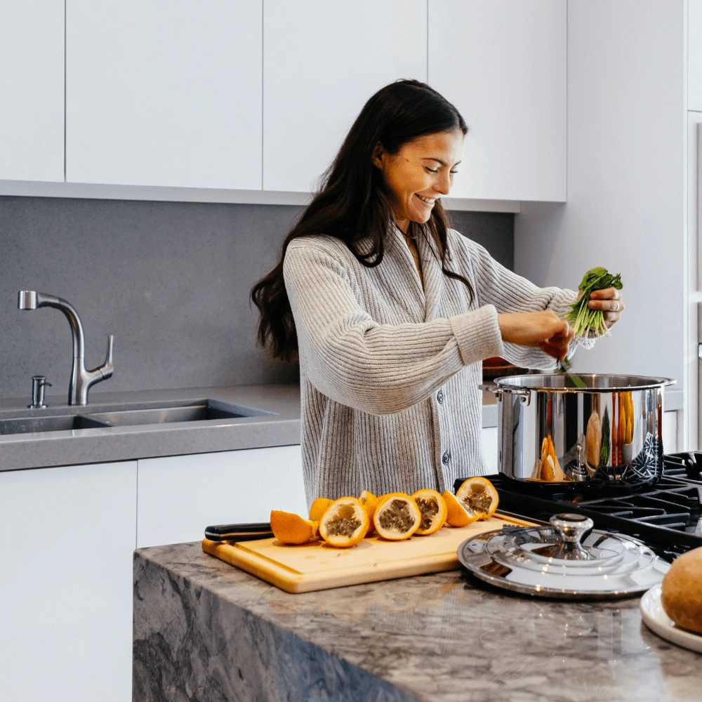 About me 2 Ellie Monroe in her cozy North Carolina kitchen smiling while cooking